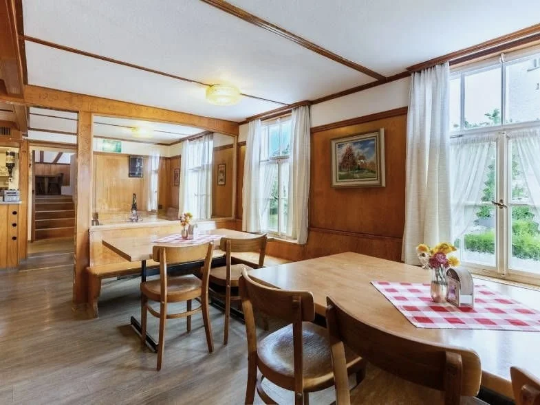 Gemütliche Gaststube des Restaurants Linde mit Holzvertäfelung und Tischen.