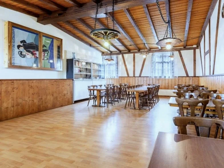 Grosser Saal im Restaurant Linde mit Holztischen und Deckenbalken für Feiern und Anlässe.